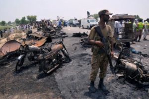 Soldier stands guard amid burnt out cars and motorcycles in Bahawalpur, Pakistan
