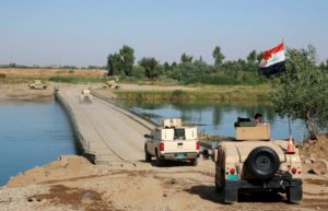 Iraqi army armored fighting vehicles (AFV) cross as military pontoon bridge one the way to the frontline in western Mosul