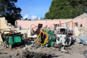 Damaged vehicles are seen at the scene of an attack outside a hotel and an adjacent restaurant in Mogadishu
