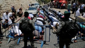 Palestinians pray just outside Jerusalem’s Old City in protest over the installation of metal detectors placed at an entrance to the compound that houses Al Aqsa mosque, on July 17, 2017