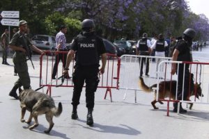 Tunisian anti-terrorism brigade officers lead their dogs after a shooting at the Bouchoucha military base in Tunis,
