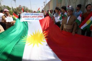 Iraqi Kurdish protesters deploy a giant flag of their autonomous Kurdistan region during a pro-independence rally outside the Kurdistan parliament building in Erbil, on July 3, 2014