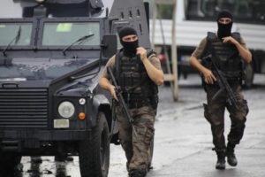 Two members of the police special forces patrol outside a police station after an attack in Istanbul