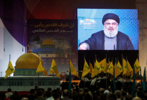 Lebanon's Hezbollah leader Sayyed Hassan Nasrallah addresses his supporters via a screen during a rally marking Al-Quds day in Beirut's southern suburbs