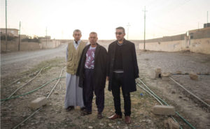 Three members of a Sunni tribal militia stand near a road on the outskirts of Muneira, Iraq. After ISIS fighters were driven out last fall, militiamen set fire to houses belonging to residents accused of sympathizing with the militants.
