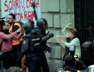 A woman is grabbed by riot police near a polling station for the banned independence referendum in Barcelona