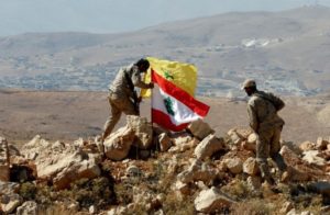 Hezbollah fighters put Lebanese and Hezbollah flags at Juroud Arsal, Syria-Lebanon border