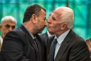 Fatah’s Azam al-Ahmad (right) and Saleh al-Aruri of Hamas kiss after signing a reconciliation deal in Cairo on Thursday.